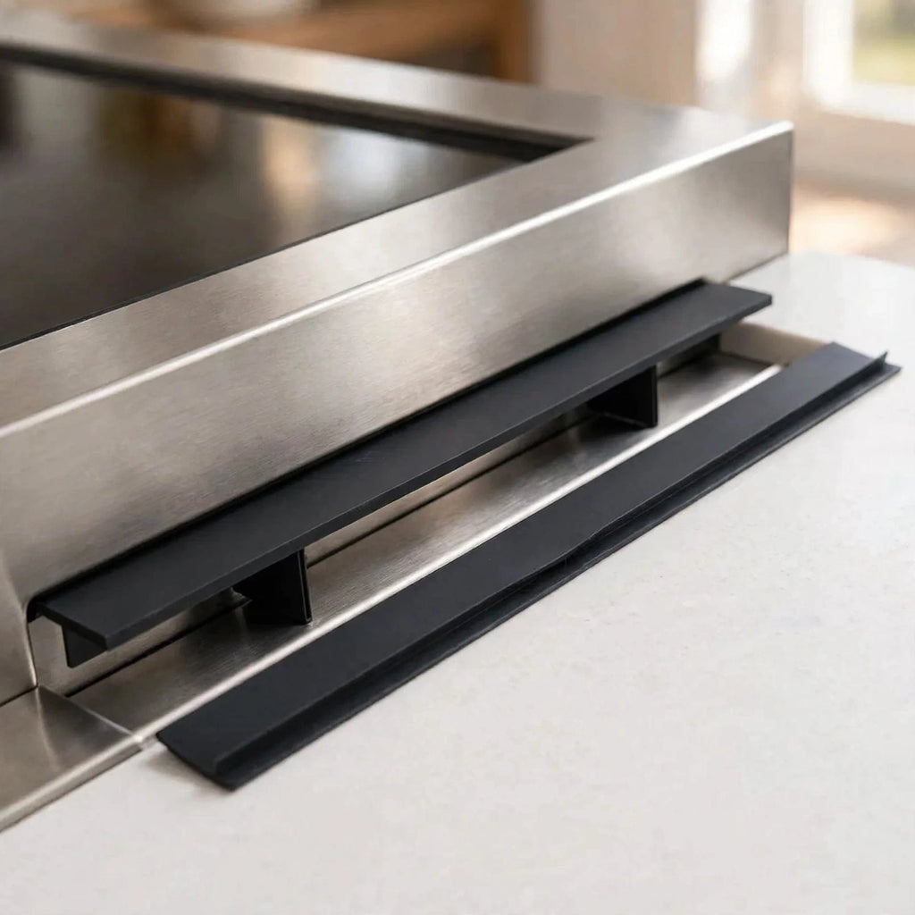Black silicone stove gap covers installed between a stove and countertop
