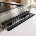 Black silicone stove gap covers installed between a stove and countertop